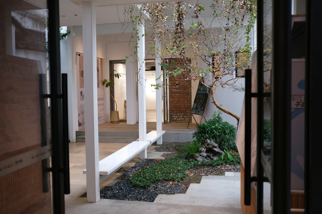 A modern courtyard with plants and a white bench