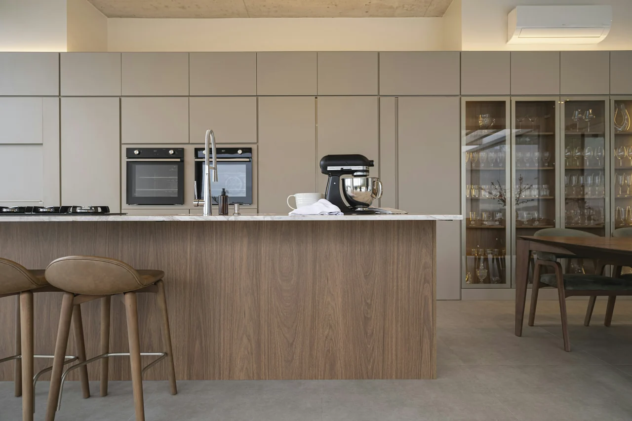 A warm modern kitchen with an island and bar stools