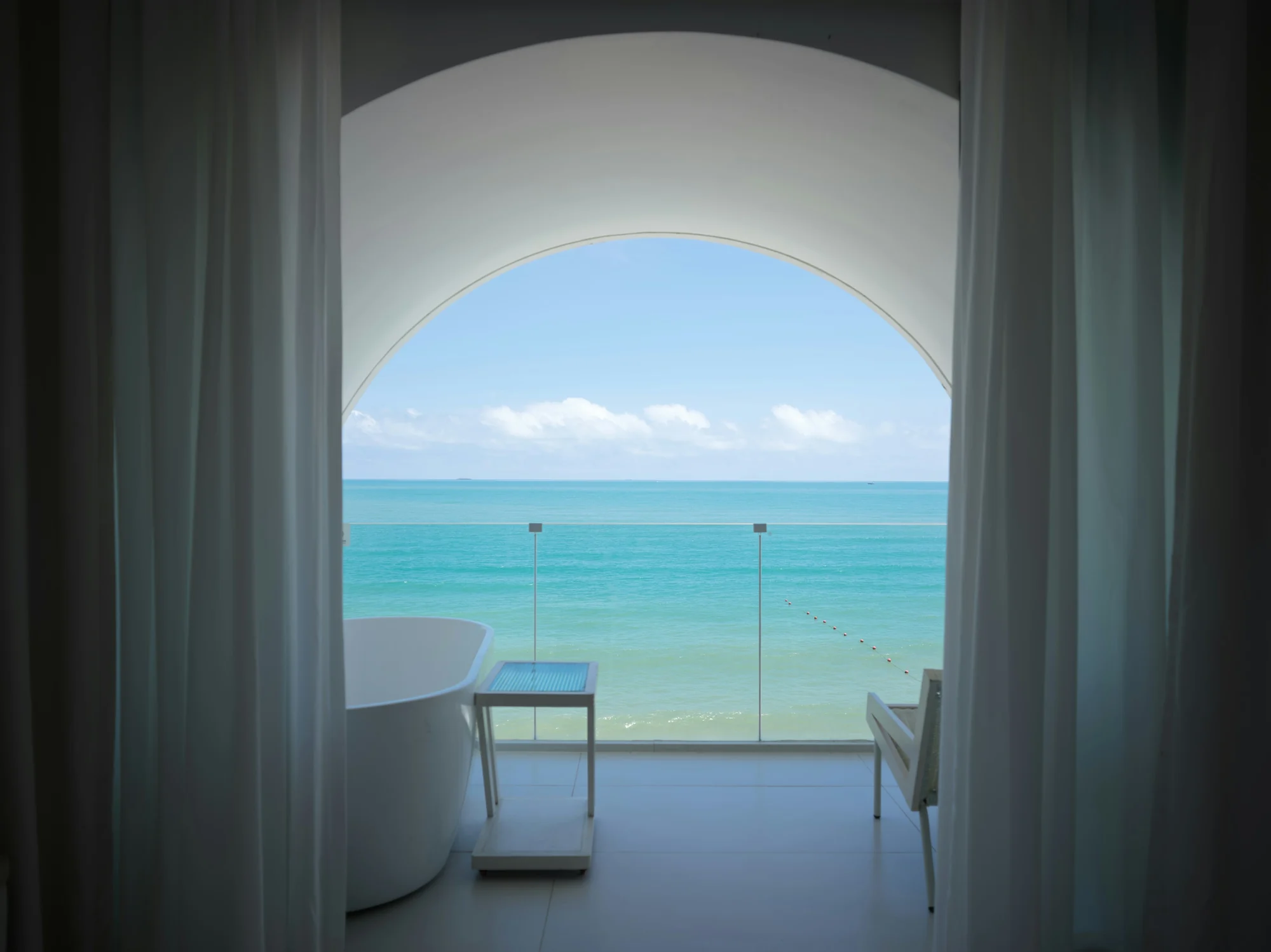 A freestanding bath looking out over a turquoise ocean